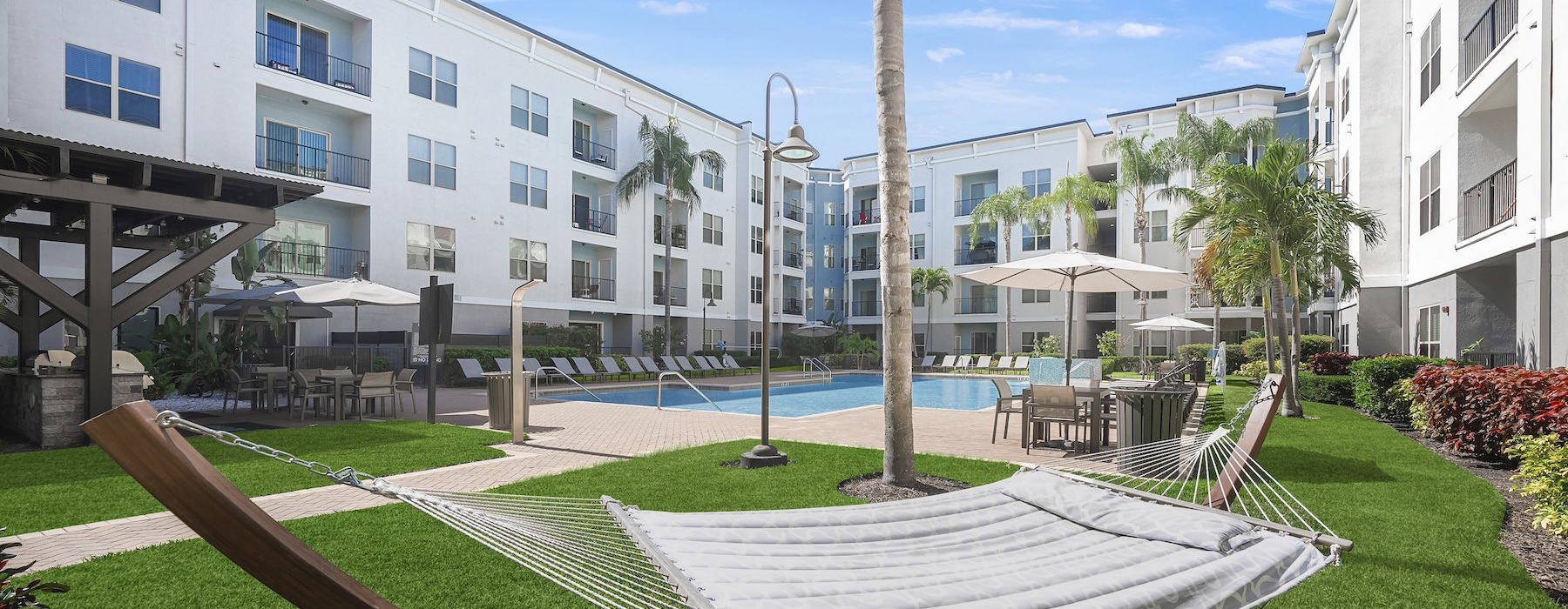resort style pool with seating hammock in a courtyard